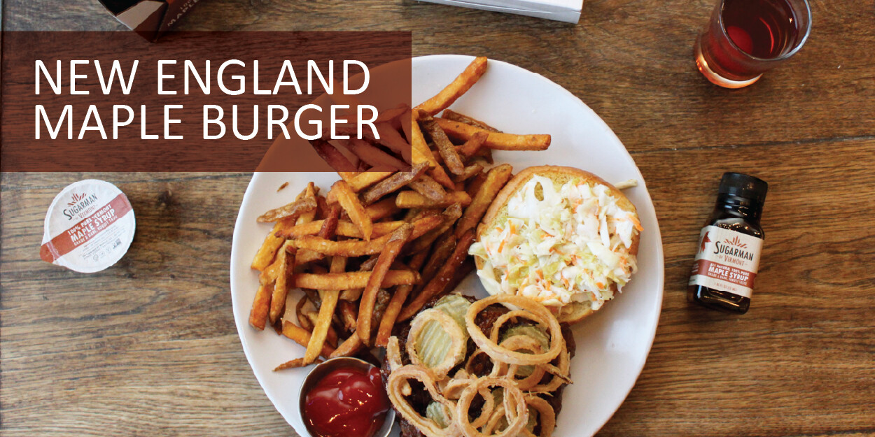 Plate featuring a New England Maple Burger, fries, and toppings, with maple syrup on the side.