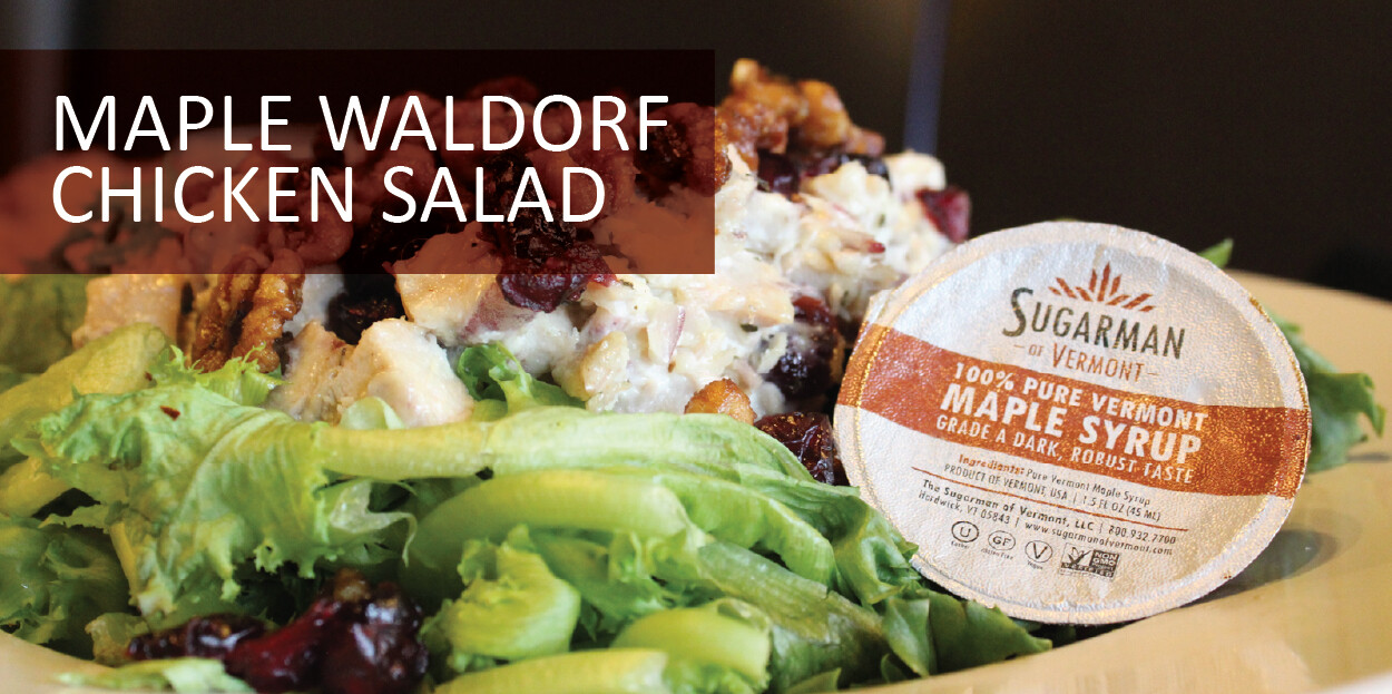 Plate featuring maple Waldorf chicken salad with a side of greens and maple syrup packet.